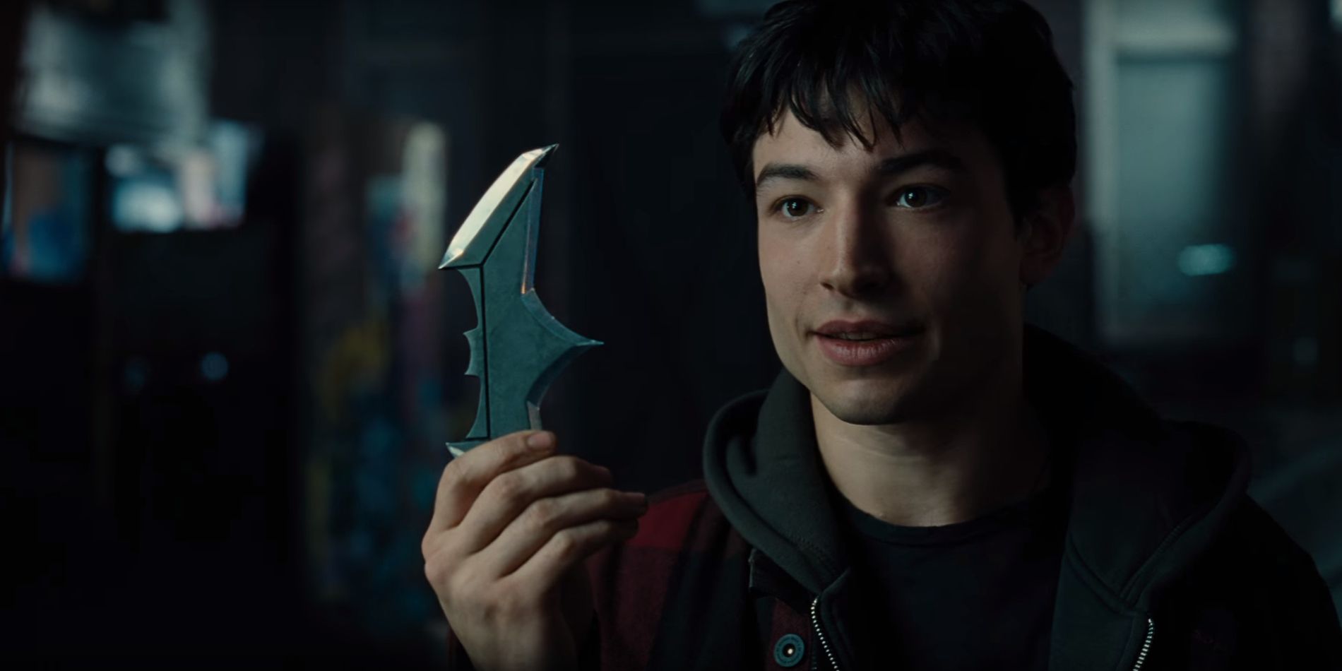 Ezra Miller as Barry Allen, holding a Batarang, in Justice League