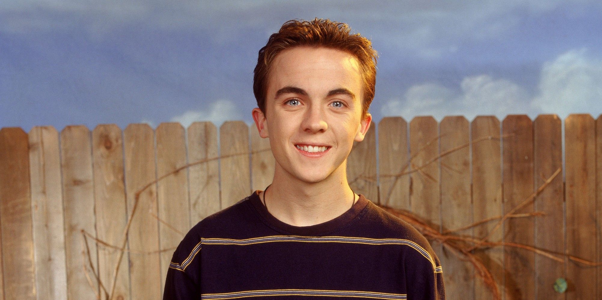 Frankie Muniz in front of a fence in Malcolm In The Middle
