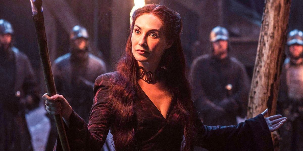 Melisandre holding a torch with soldiers behind her in Game of Thrones.