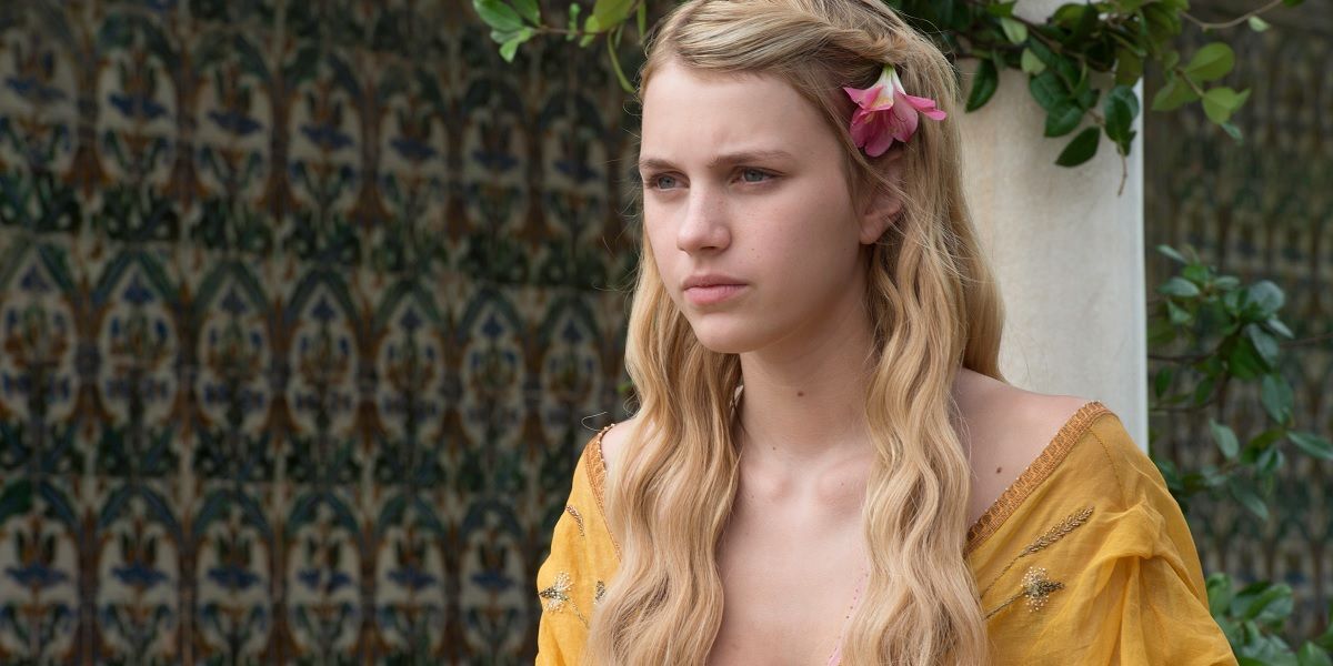 Myrcella Baratheon frowning while standing in a garden in Game of Thrones.