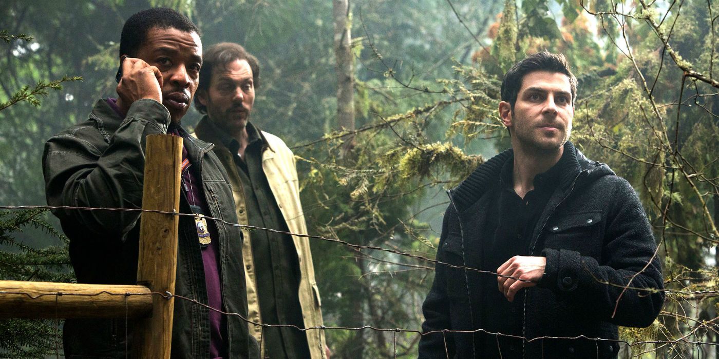 Three men by a wire fence in the woods in the Grimm TV Series