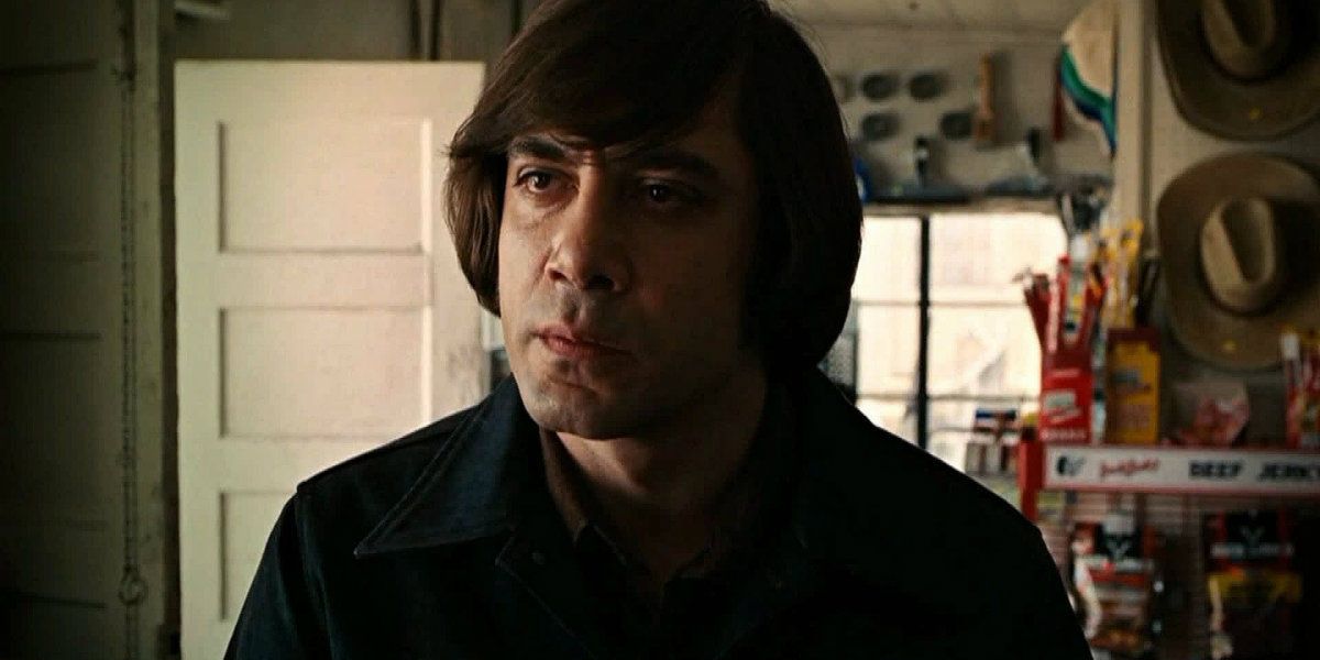 Anton Chigurh em uma estação fas parecendo sério em 'No Country for Old Men'