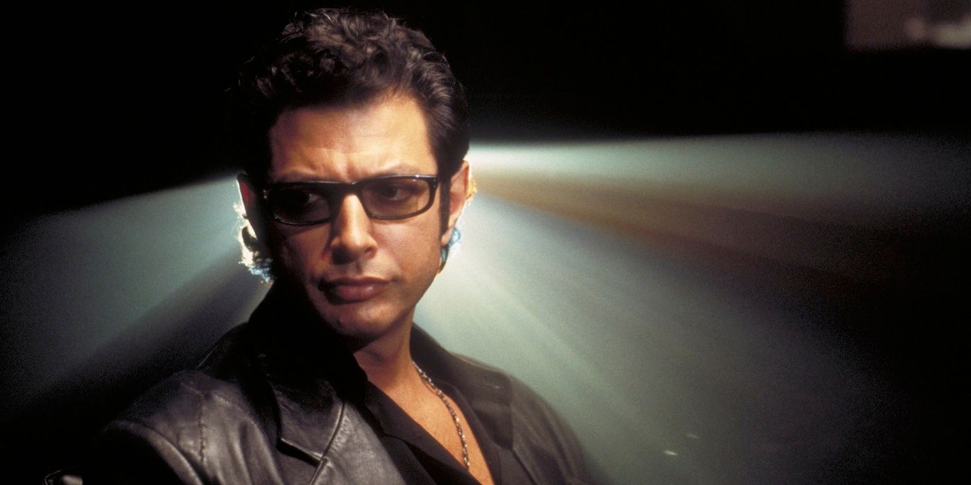 Dr. Ian Malcolm franzindo a testa com uma luz de projetor atrás dele em Jurassic Park.