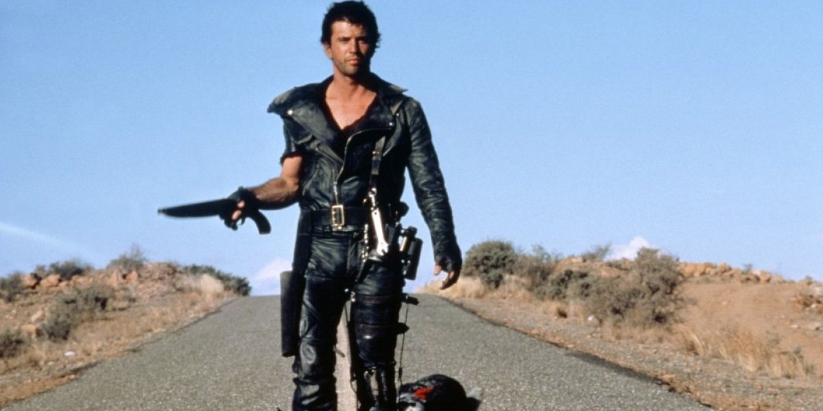 Mel Gibson walks with a gun in Mad Max 2