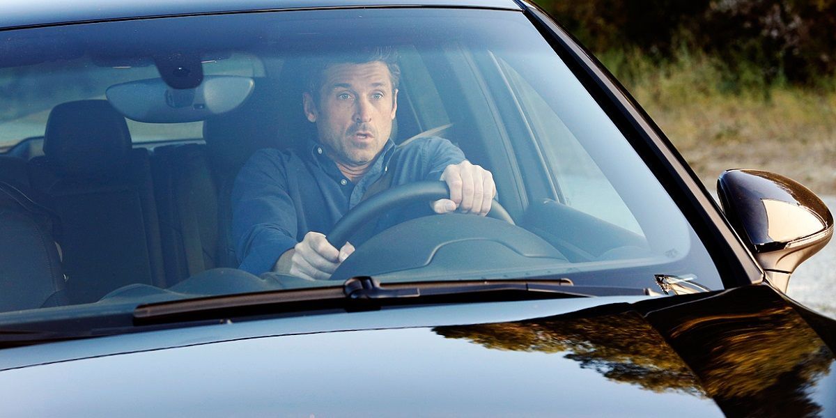 Derek Shepherd dirigindo um carro e parecendo chocado em Grey's Anatomy.