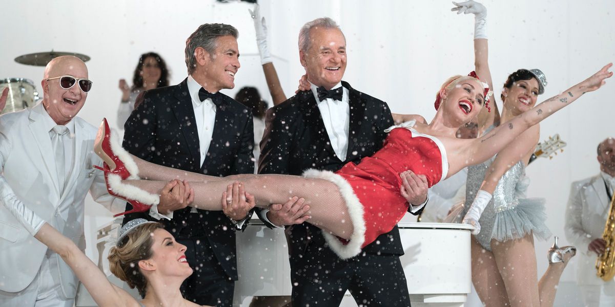 George Clooney and Bill Murray hold up Miley Cyrus in A Very Murray Christmas