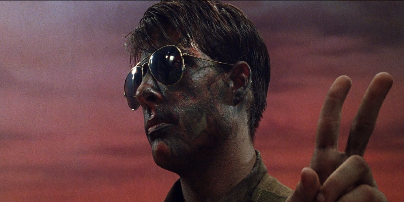 Jason Schwartzman como Max usando óculos escuros e fazendo sinal de paz em Rushmore, de Wes Anderson