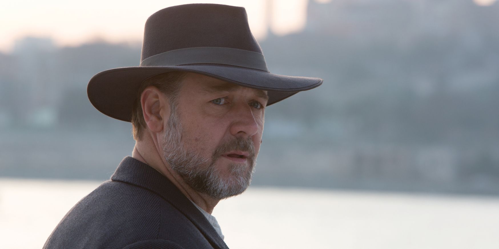 Russell Crowe em The Water Diviner usando um chapéu e virado para o lado