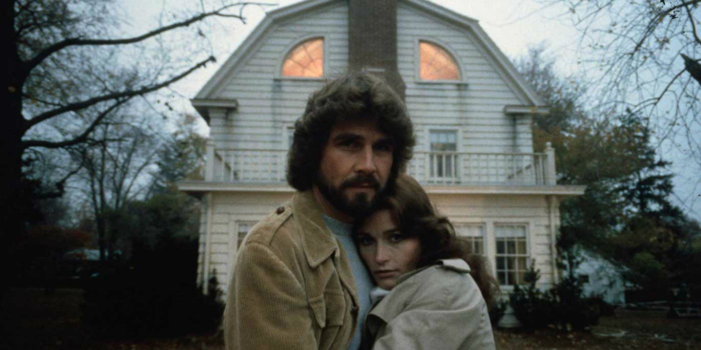 Couple outside the house in The Amityville Horror.