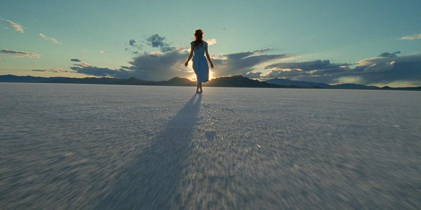 A woman in white walks across a salt flat in The Tree of Life 