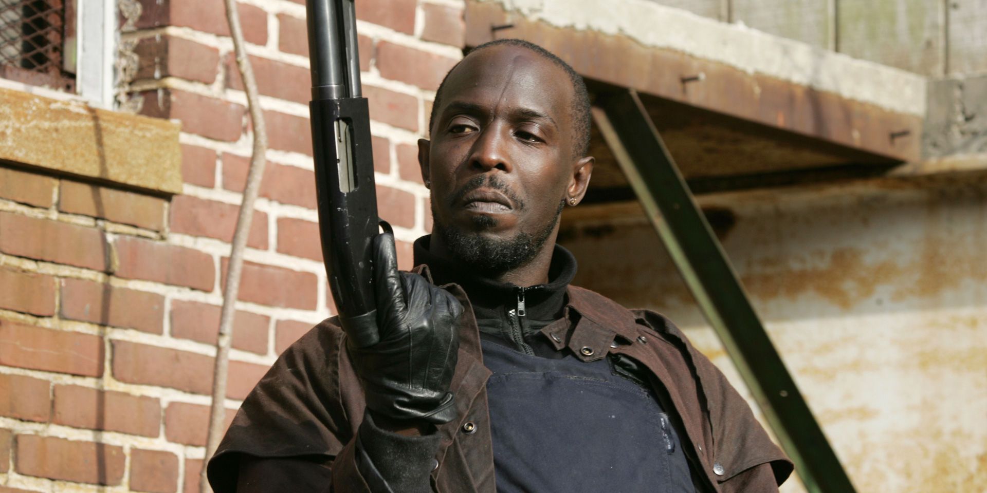 Omar Little (Michael Kenneth Williams) cocks a shotgun outside housing projects in The Wire.
