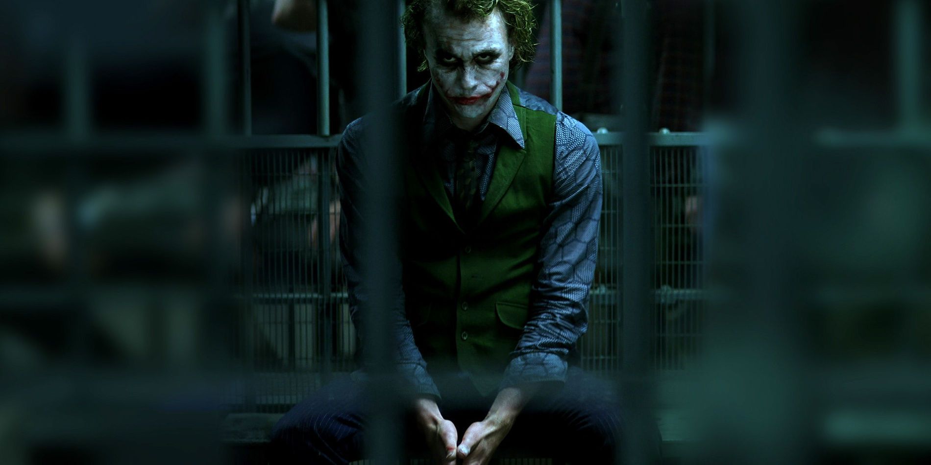 Heath Ledger as The Joker sitting in a cell in The Dark Knight (2008)
