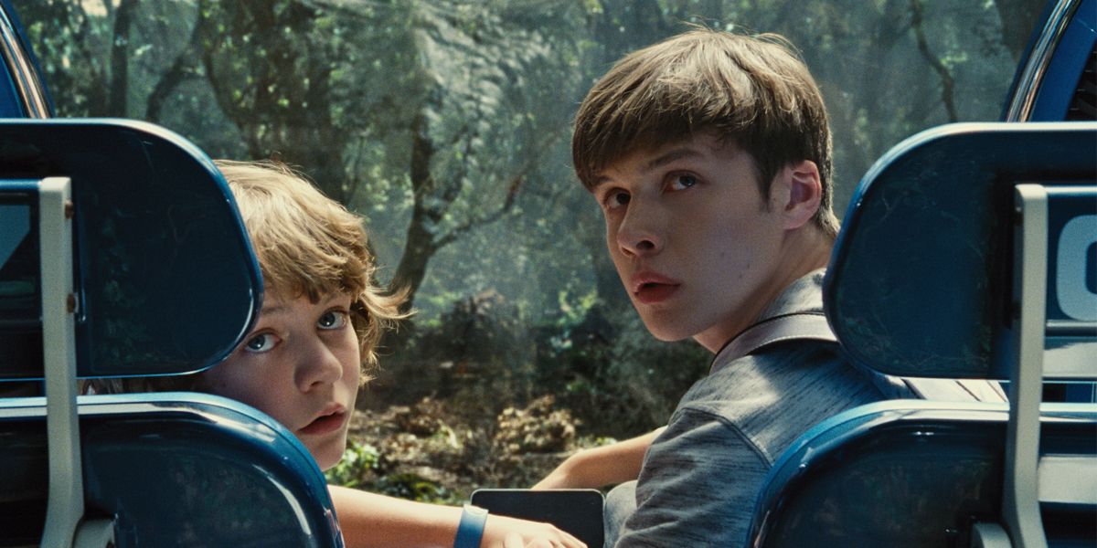 Ty Simpkins and Nick Robinson looking behind them in Jurassic World