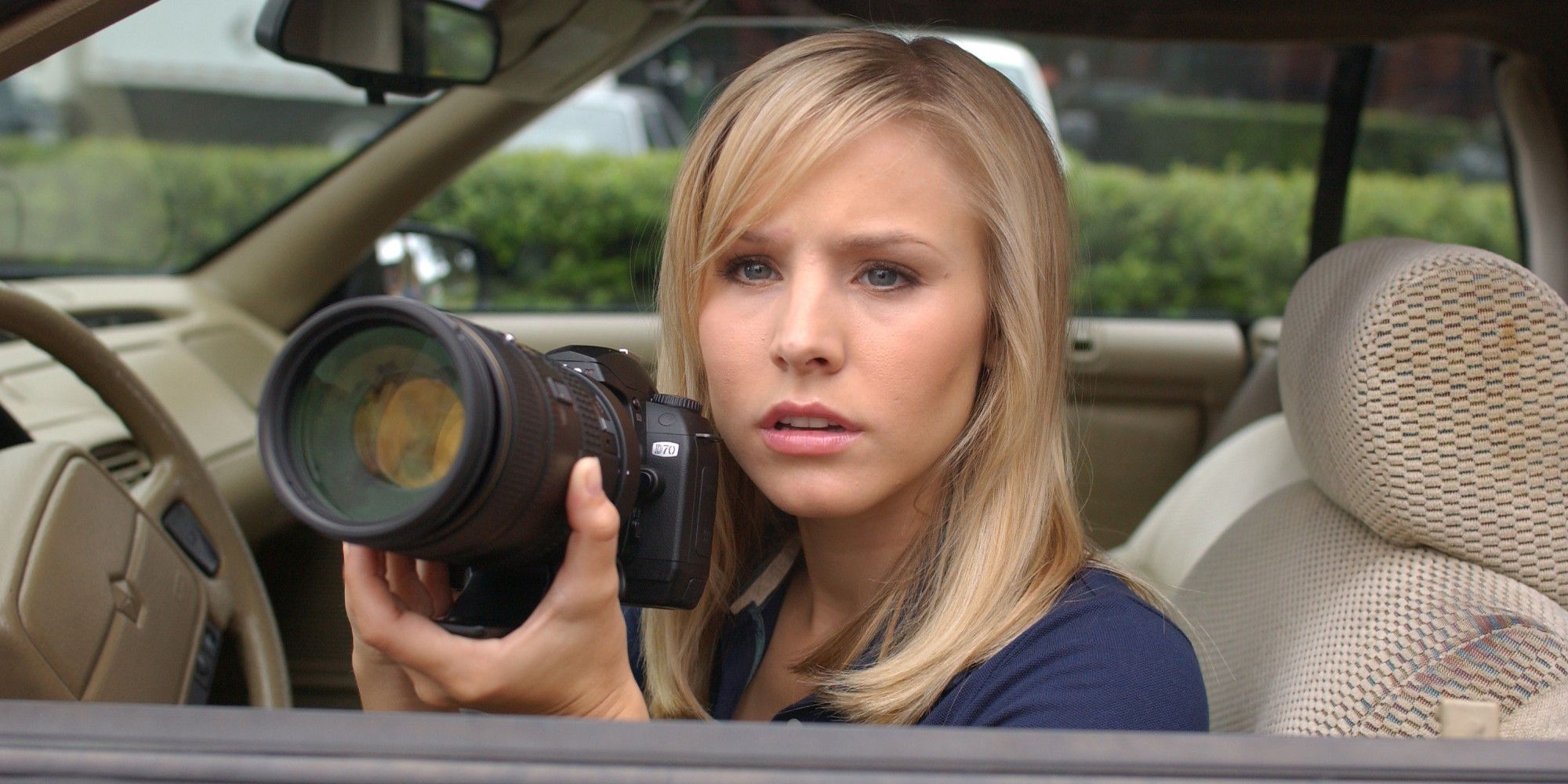 Kristen Bell as Veronica Mars with her camera in a car in Veronica Mars.