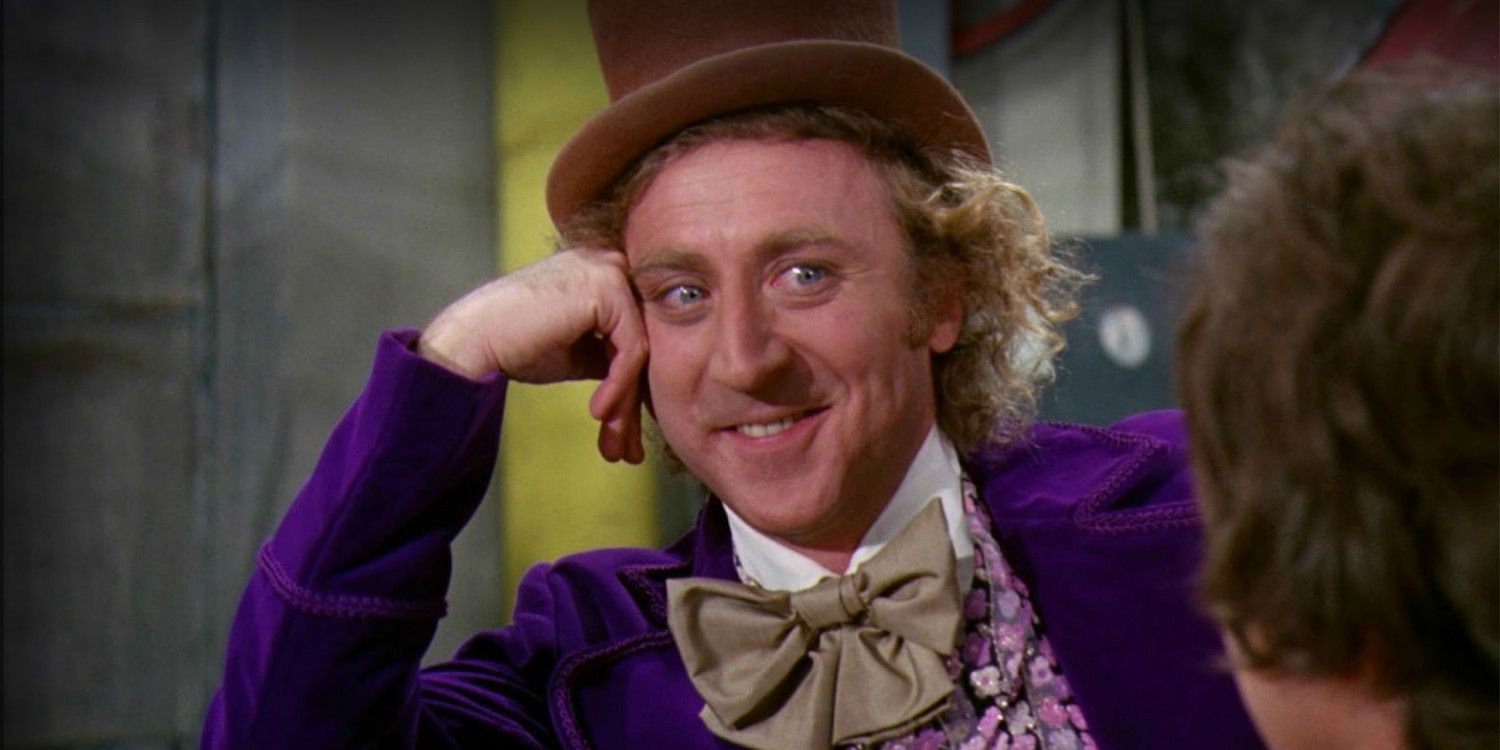Gene Wilder as Willy Wonka resting his head on his hand and smiling