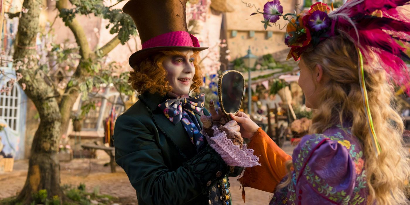 Alice uses a hand mirror to admire a hat while the Mad Hatter looks on in Alice Through The Looking Glass