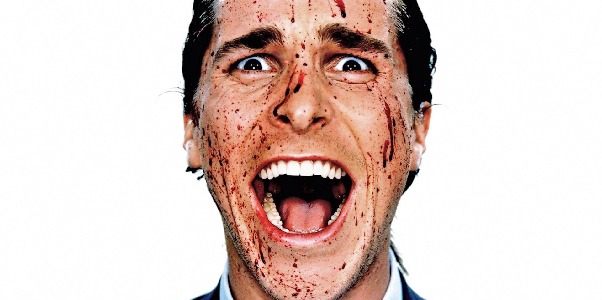 Patrick Bateman screaming with his face covered in blood in American Psycho.
