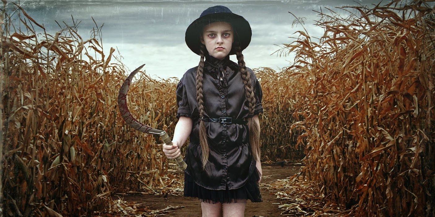 A young girl holding a sickle while standing on a corn field in Children of the Corn.