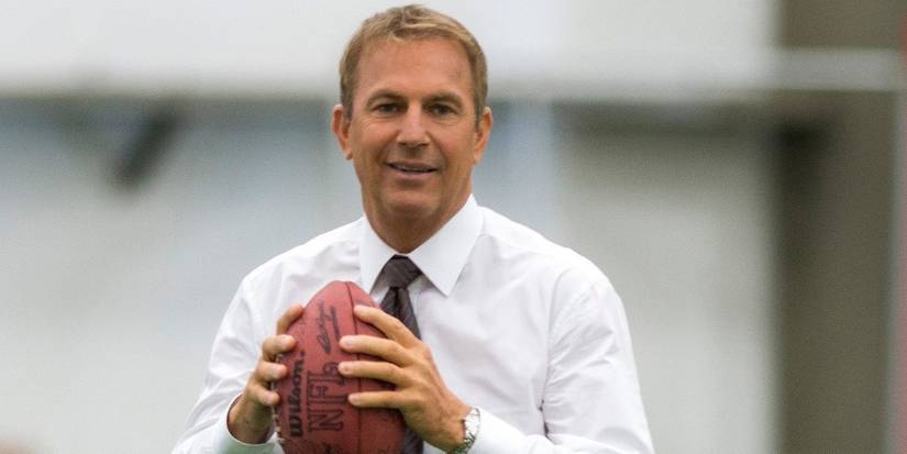 Kevin Costner holding a football in Draft Day
