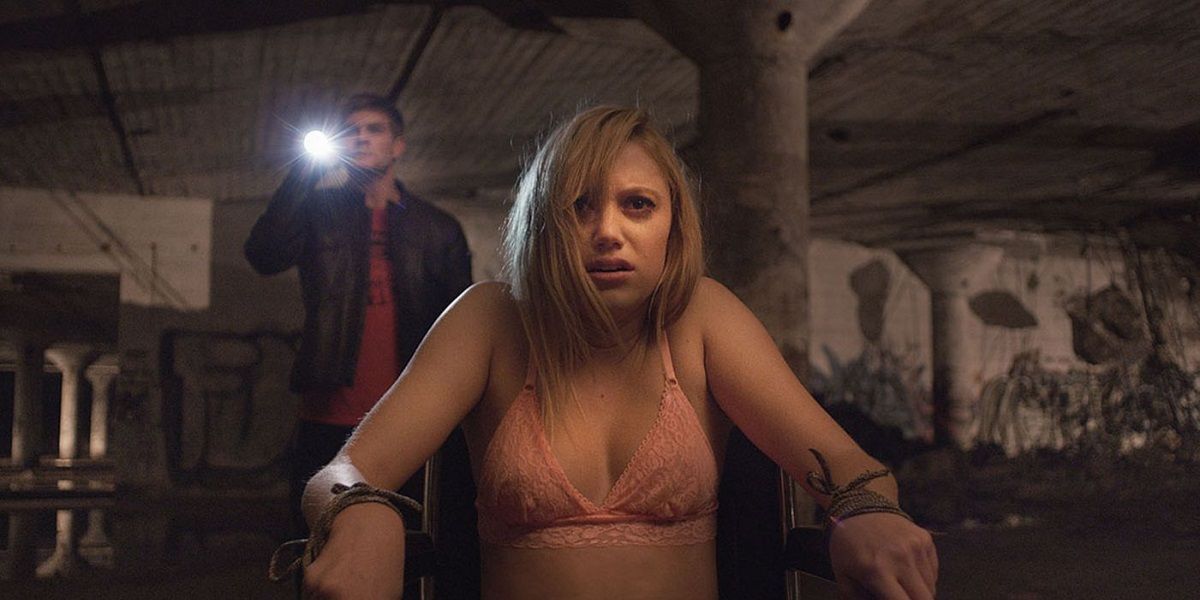 Jay sitting in a chair looking scared in It Follows
