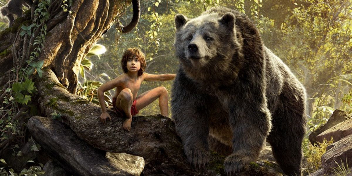 Mowgli sits on a tree and Baloo stands beside him