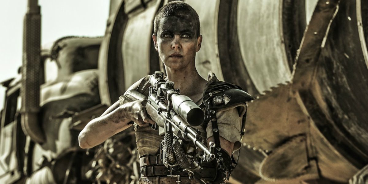 Charlize Theron as Furiosa holding up a weapon in Mad Max: Fury Road