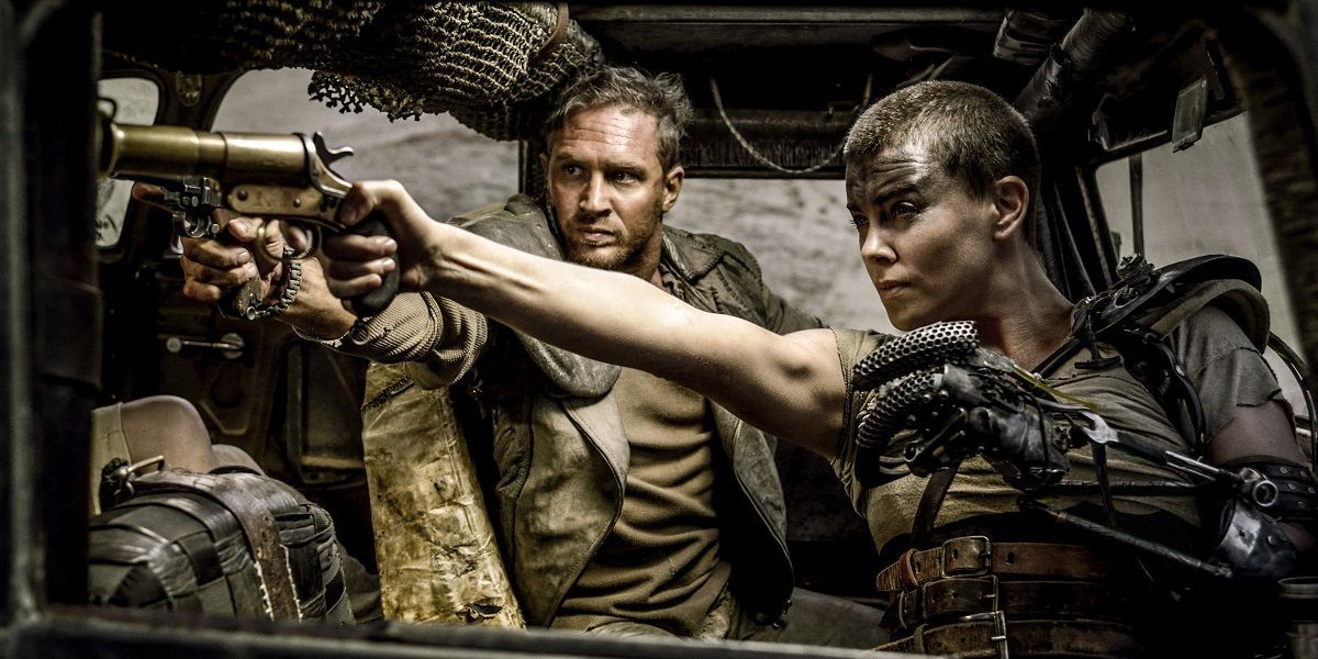 Max and Imperator Furiosa pointing their guns while driving a car in Mad Max: Fury Road