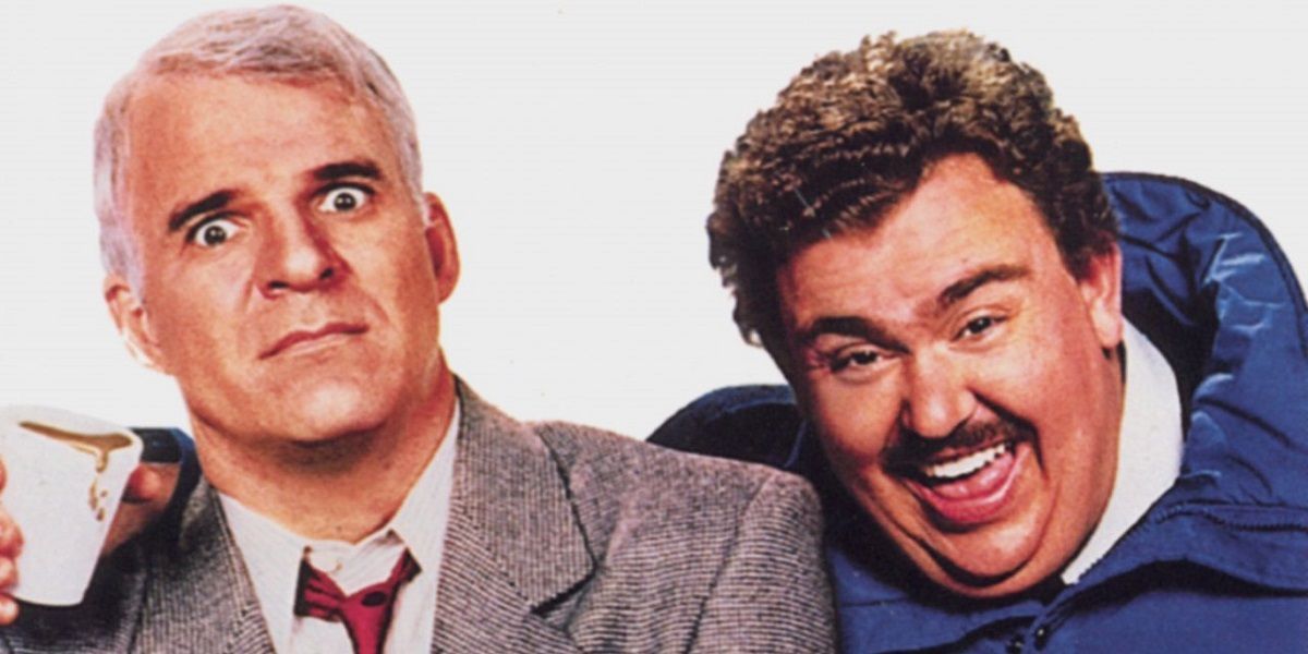 John Candy laughs while Steve Martin looks shocked in Planes Trains and Automobiles