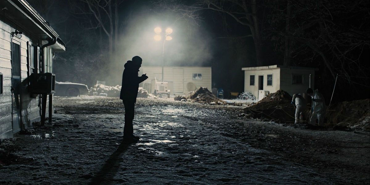 A man standing outside a house in the dark in Prisoners.