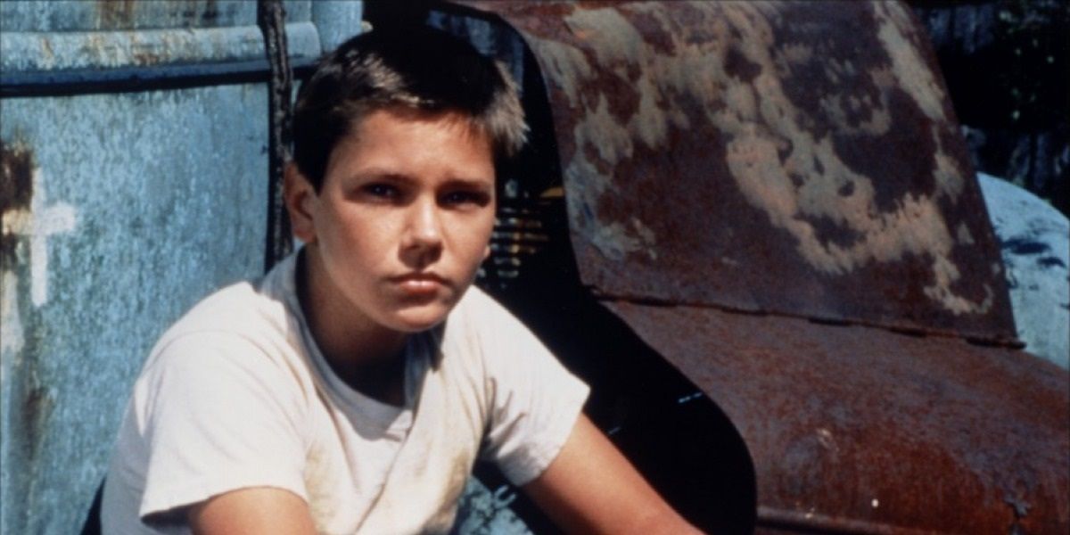 River Phoenix sitting and looking at something in Stand by Me