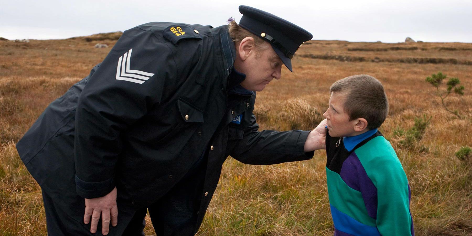 Brendan Gleeson as a police officer holding a boy by the collar in The Guard.