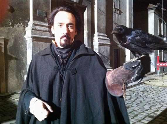 John Cusack with a raven on his arm