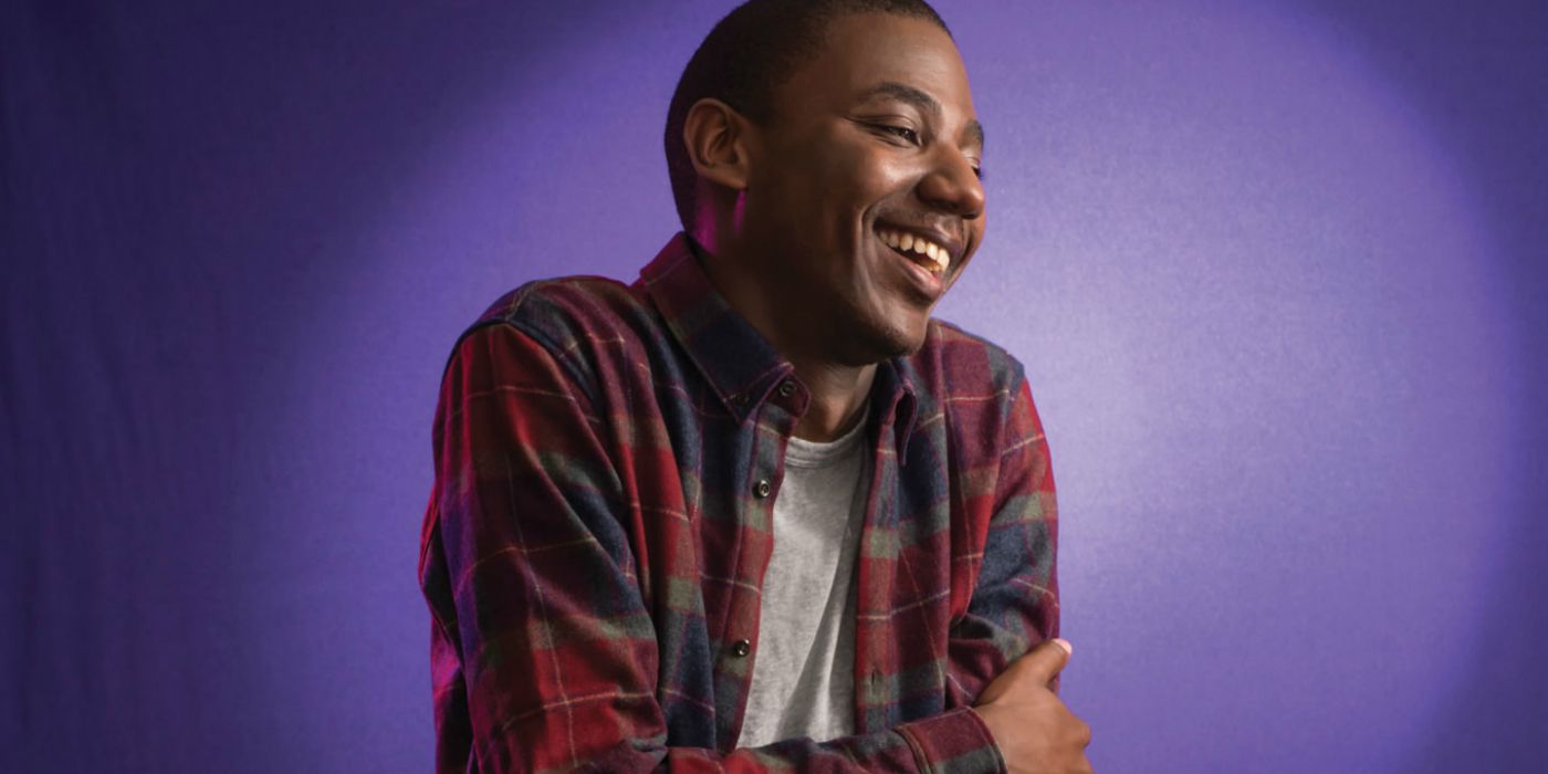 Jerrod Carmichael laughing in front of a purple background.