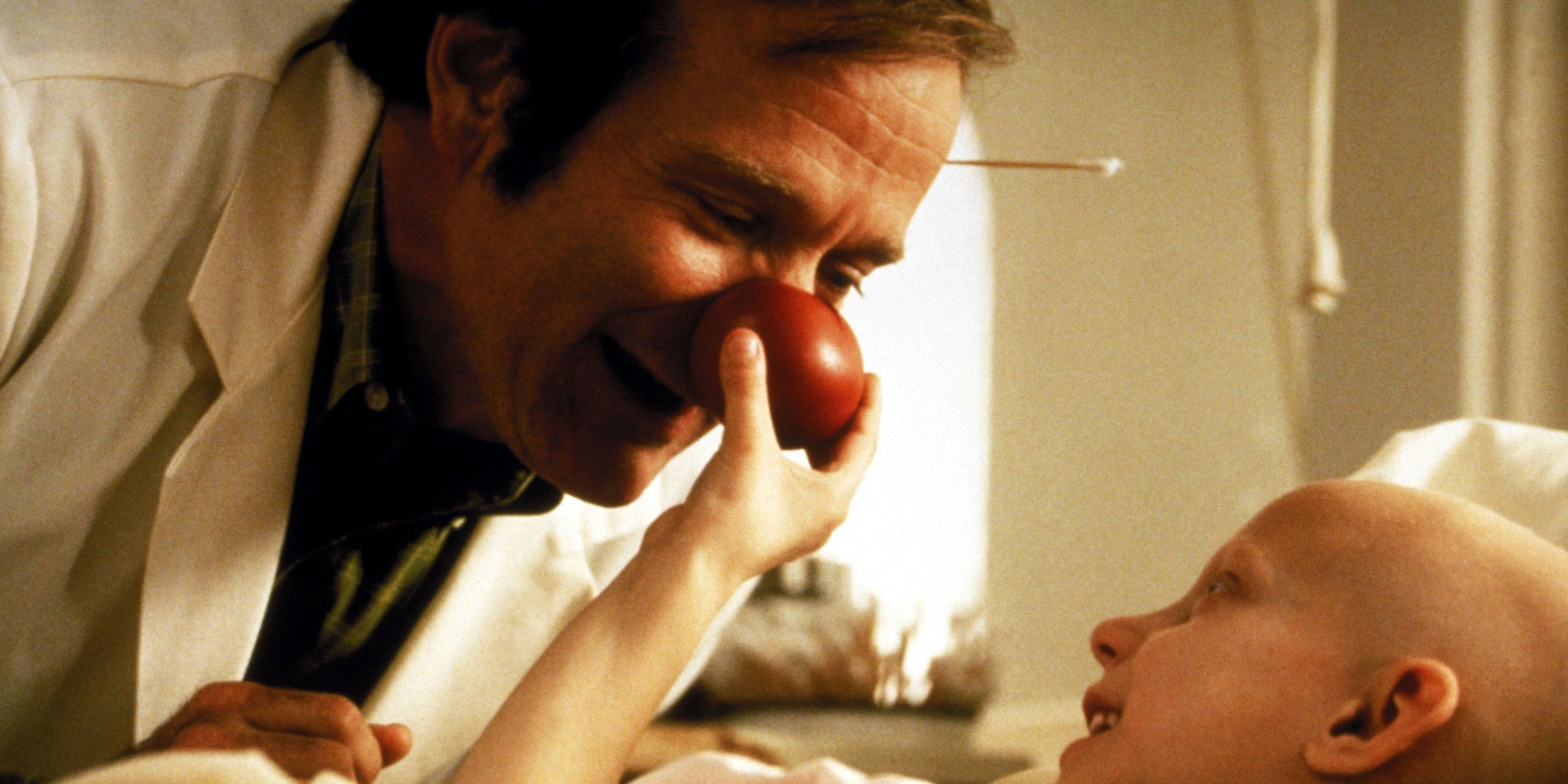 A boy pressing on a doctor's clown nose in Patch Adams