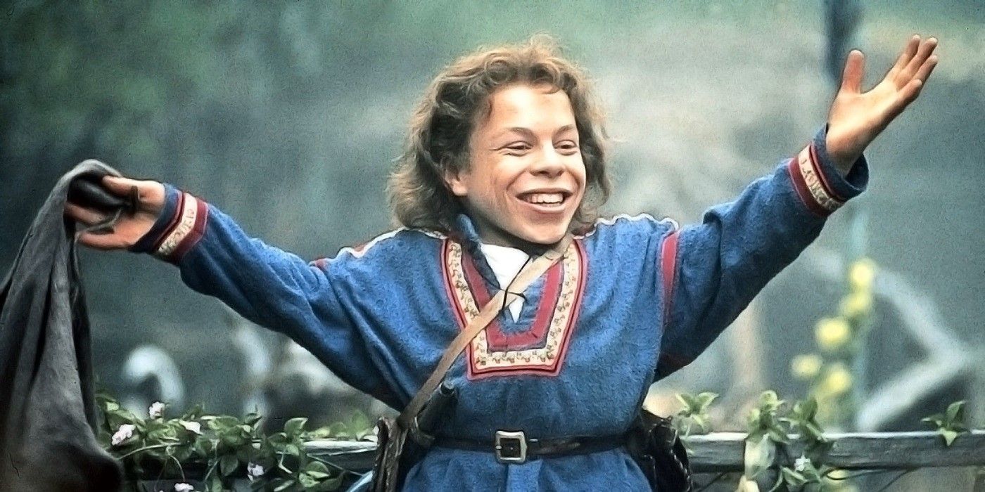 Warwick Davis smiling and waving his arms in Willow