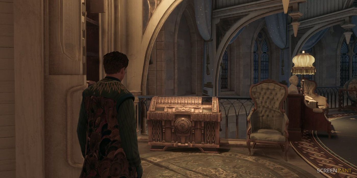 A Hogwarts Legacy student standing in the Ravenclaw common room and looking at the House Chest.