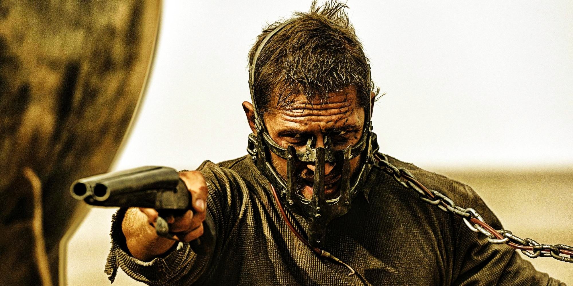 Tom Hardy as Max aiming a gun while waering a mask in Mad Max Fury Road