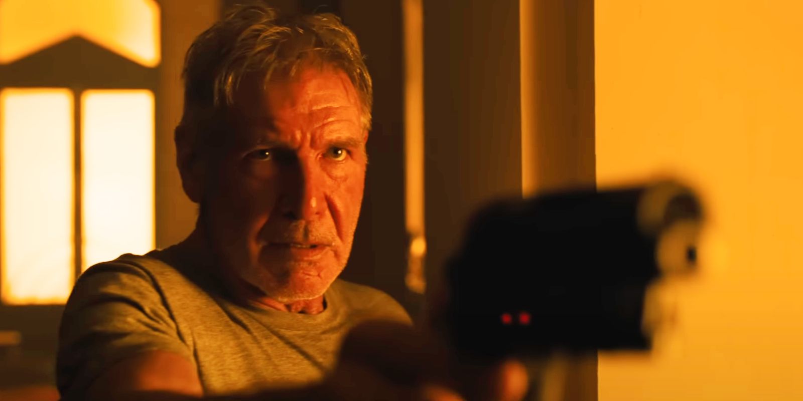 Harrison Ford as Deckard in Blade Runner 2049 holding a gun