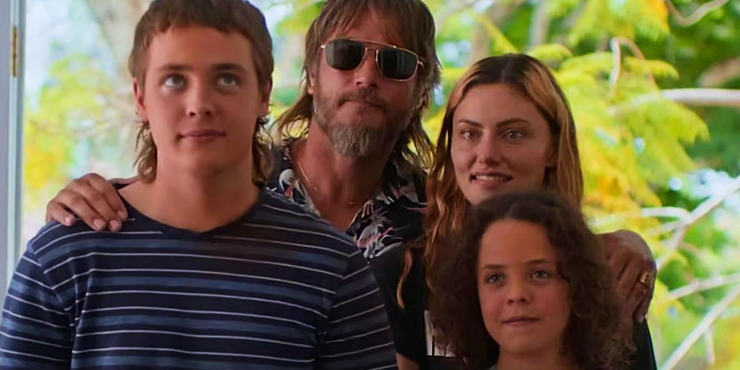 Lyle wraps his arms around Frances, Gus, and Eli Bell in Boy Swallows Universe.