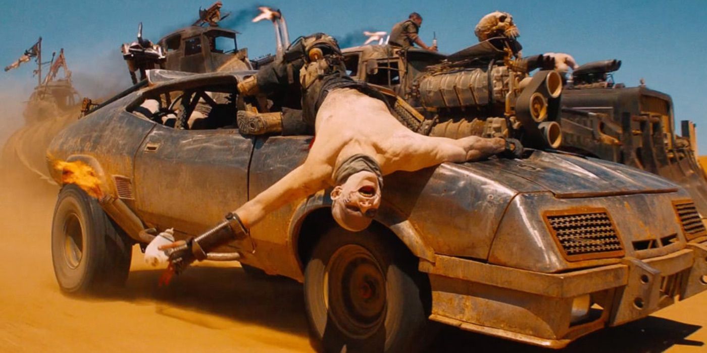 Nux hanging off the hood of a car in Mad Max: Fury Road