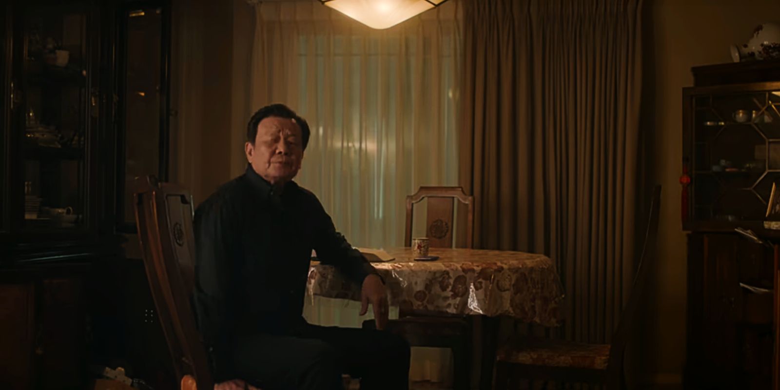 Big Sun sits at a table in The Brother Sun.